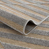 Close-up of the Webuye 3D Outdoor Area Rug showing its geometric design, dark gray and multi brown colors, and woven texture. Fold