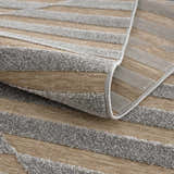 Close-up of Webuye 3D Outdoor Area Rug showing gray textured stripes and woven backing. Geometric, contemporary style. Fold