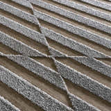 Close-up of Webuye 3D Outdoor Area Rug with a gray geometric pattern on a multi brown woven background. Texture