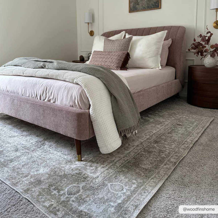 Bedroom scene with a light pink bed and a light gray Gael Boutique Washable Rug with a vintage design. Roomscene-Rectangle