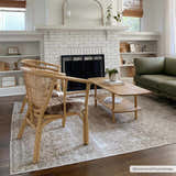 Living room scene with the Gael Boutique Washable Rug, woven chairs, wood coffee table, and olive green sofa. Roomscene-Rectangle
