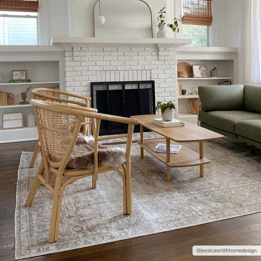 Living room scene with the Gael Boutique Washable Rug, woven chairs, wood coffee table, and olive green sofa. Roomscene-Rectangle