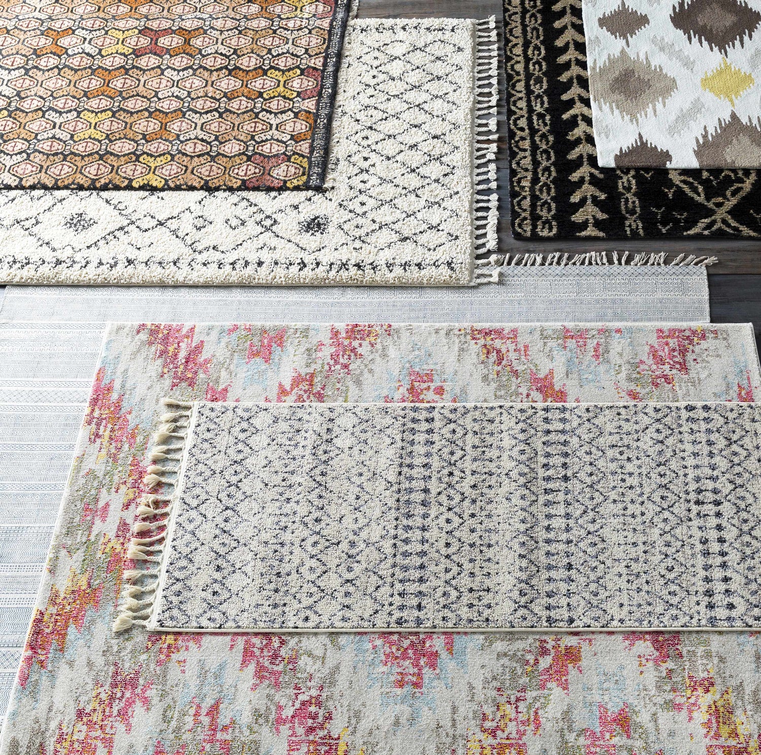 Overhead shot of assorted rugs including a Redondo Jute rug with diamond pattern and fringe. Bohemian, farmhouse style rugs. Styleshot