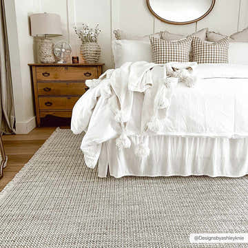 Farmhouse bedroom with a Gowan Cream Area Rug, white bedding, and a vintage wood dresser. Roomscene-Rectangle