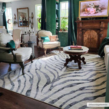 Living room with vintage decor and Gray Ecorse Zebra Print Area Rug, featuring chairs, a fireplace, and dark green accents. Roomscene-Rectangle
