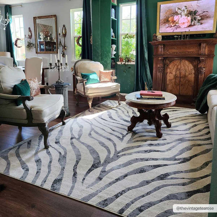 Living room with vintage decor and Gray Ecorse Zebra Print Area Rug, featuring chairs, a fireplace, and dark green accents. Roomscene-Rectangle