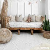 Neutral kids room with a rattan daybed on the bone-colored geometric Gyundyukoru Area Rug. Roomscene-Rectangle