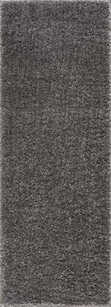 Close-up of the plush texture of the Faina Solid Dark Gray Shag Washable Area Rug. Design-Runner
