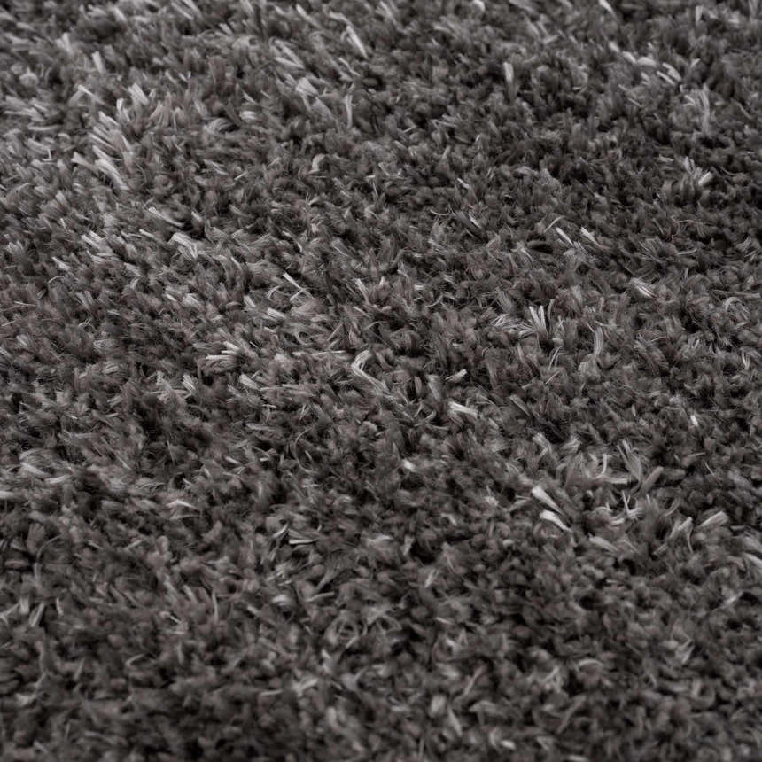 Close-up of the Faina Solid Dark Gray Shag Washable Area Rug, showing its plush texture and subtle variations in gray tones. Texture