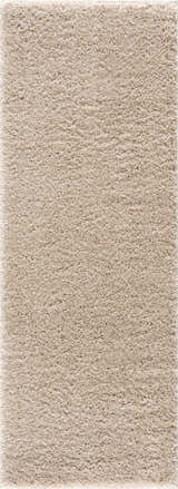 Close-up of the plush texture of the Faina Solid Beige Shag Washable Area Rug. Design-Runner