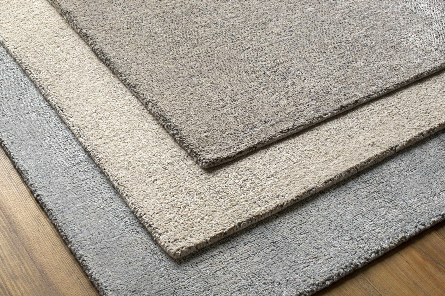 Close-up of Pantubig Area Rug showing charcoal, gray, and ivory tones. Hand-loomed wool and viscose texture. Styleshot