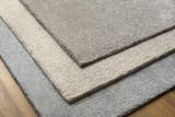 Close-up of the Phalaborwa Area Rug, a hand-loomed contemporary rug in gray, light beige, and tan. Wool and viscose texture. Styleshot