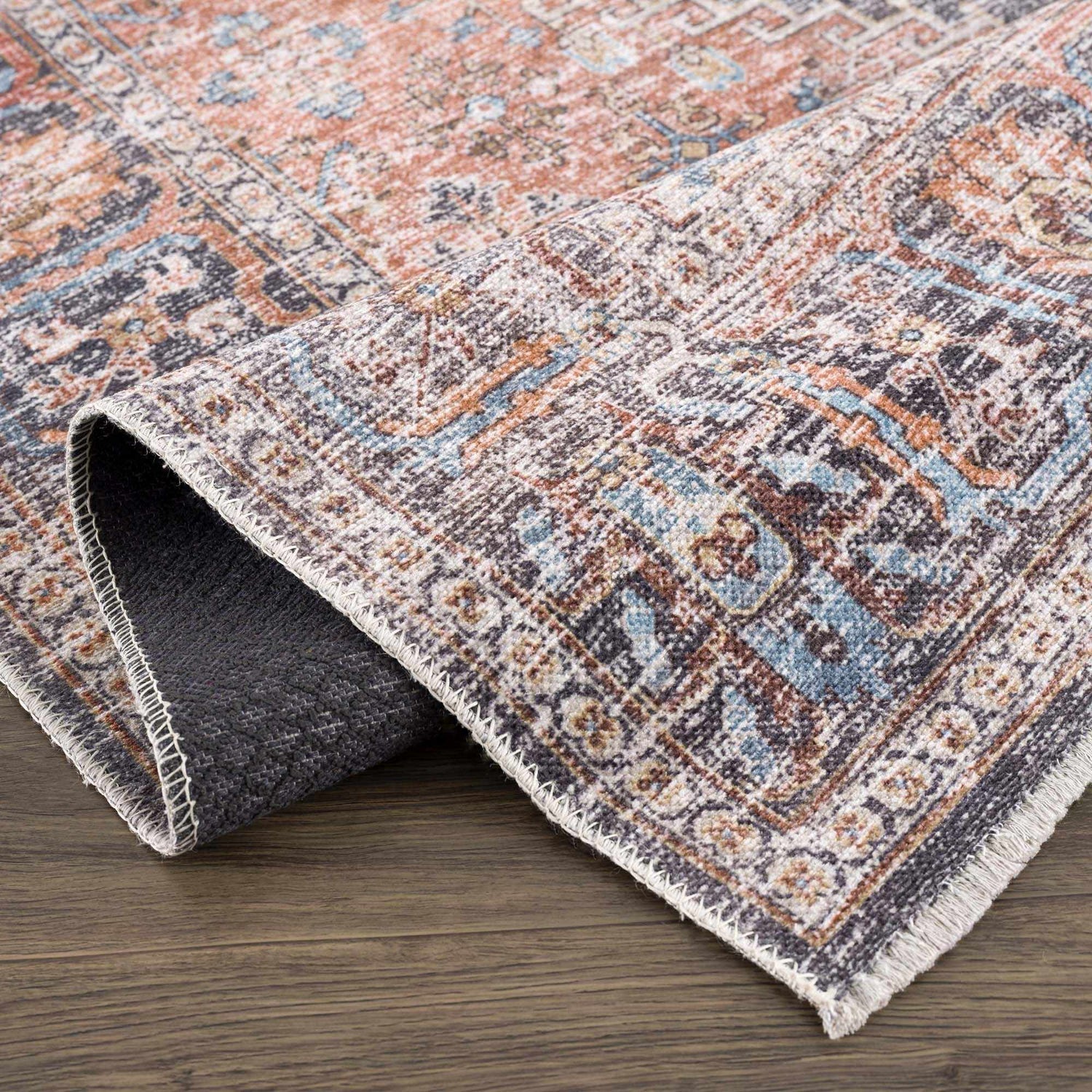 Close-up of Blue Burgundy Holi-2302 rug showing its Persian-style design, beige, blue, and burgundy colors, and machine-printed texture. Fold