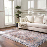 Living room scene with a cream sofa and the vintage-style Holi-2305 Boutique Washable Rug in burgundy, peach, and slate. Roomscene-Rectangle