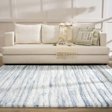 Living room scene with a white sofa and the blue and white Mette Area Rug, creating a calm and inviting space. Roomscene-Rectangle