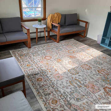 Living room scene with a Herstmonceux Area Rug. The rug is camel, pink, and gray with a traditional floral pattern. Roomscene-Rectangle