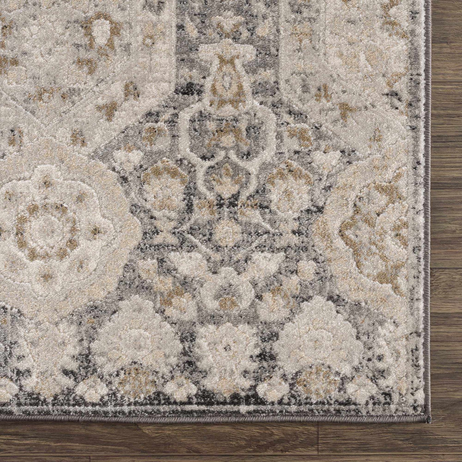 Close-up of the Minoa Area Rug showing beige, black, charcoal, gray, and mustard floral pattern and machine-woven texture. Swatch
