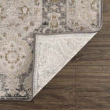 Close-up of the Minoa Area Rug showing its beige, black, and gray bohemian design and machine-woven construction. Fold