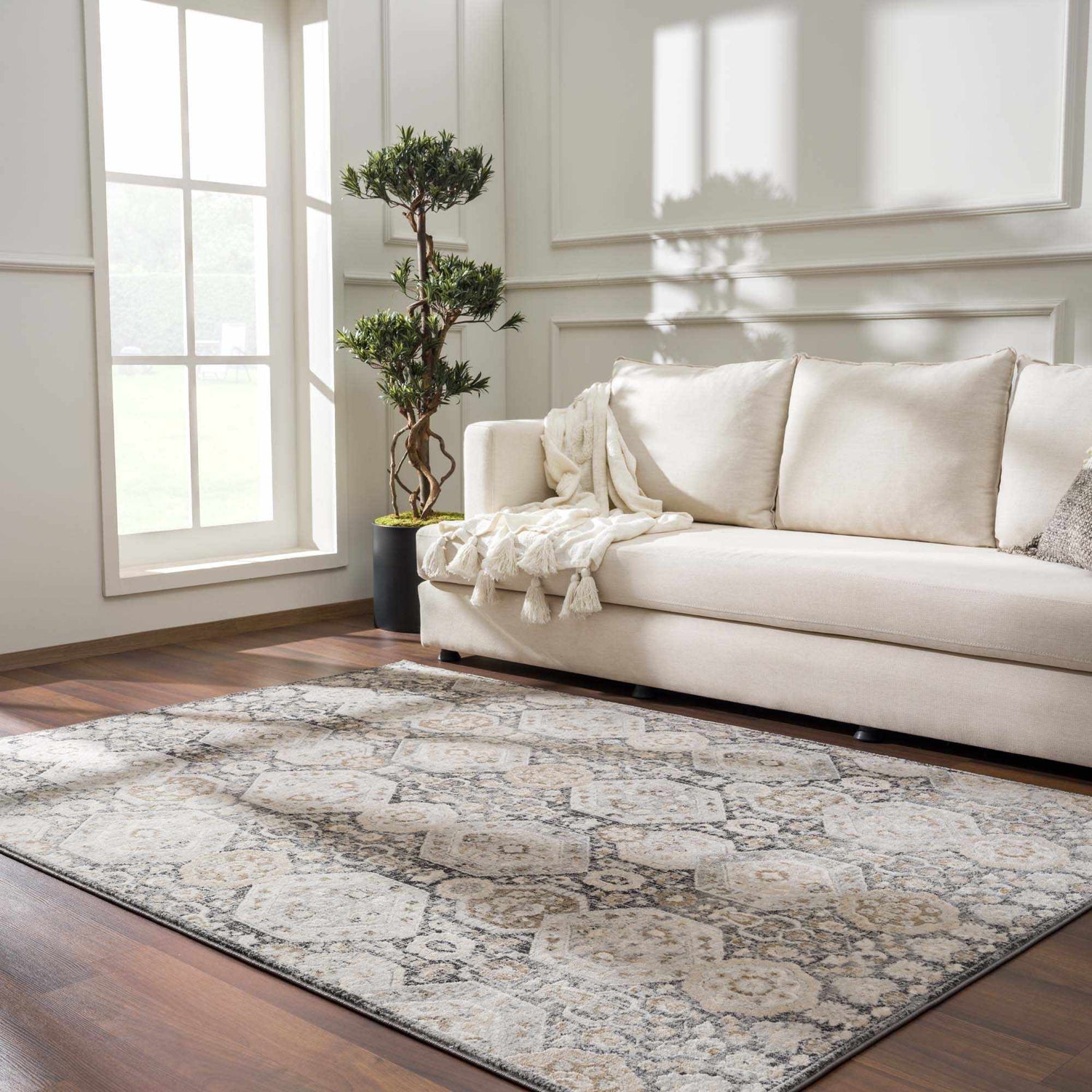 Living room scene with a beige sofa and the beige, black, and gray Minoa Area Rug on a wood floor. Roomscene-Rectangle