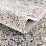 Close-up of the Parkerfield Cream & Blue Area Rug showing its soft texture and bohemian-inspired beige, blue, and cream pattern. Fold