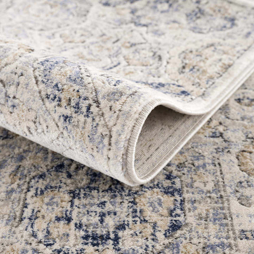 Close-up of the Parkerfield Cream & Blue Area Rug showing its soft texture and bohemian-inspired beige, blue, and cream pattern. Fold