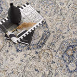 Close-up of Parkerfield Cream & Blue Area Rug. Features a beige, blue, and gray traditional pattern with a soft, textured pile. Styleshot