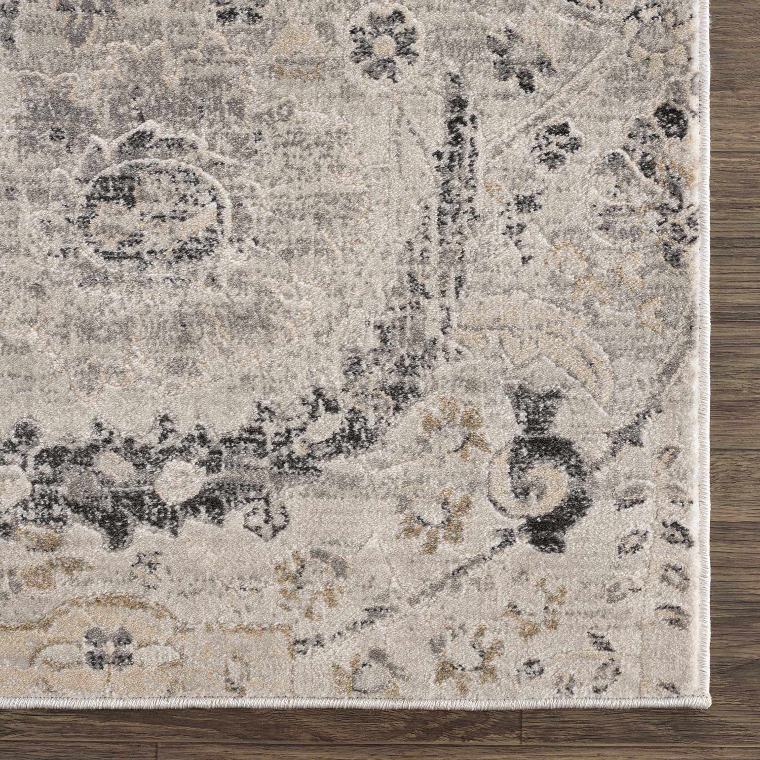Close-up of the Georgiana Area Rug. Beige, black, and gray floral pattern on a soft, textured polypropylene rug. Swatch