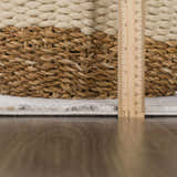 Close-up of the Georgiana Area Rug showing the pile height with a ruler and a woven basket. Beige and gray tones. Pile