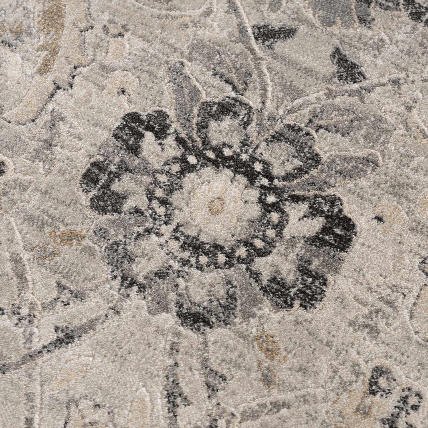 Close-up of the Georgiana Area Rug showing a beige, black, and gray floral pattern and soft, textured weave. Texture