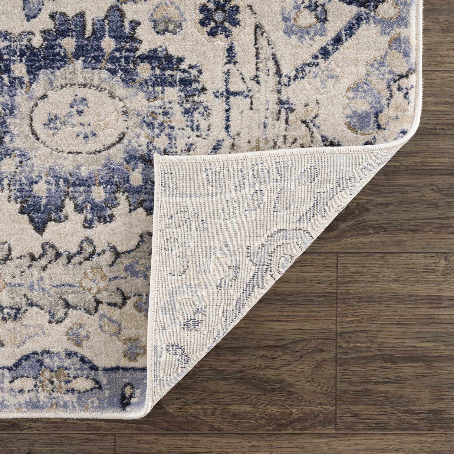 Close-up of Georgiana Blue & Beige Oushak Rug showing its floral pattern, soft texture, and durable machine-woven construction. Fold