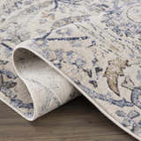 Close-up of the Georgiana Blue & Beige Oushak Rug showing its floral pattern, soft texture, and durable machine-woven construction. Fold