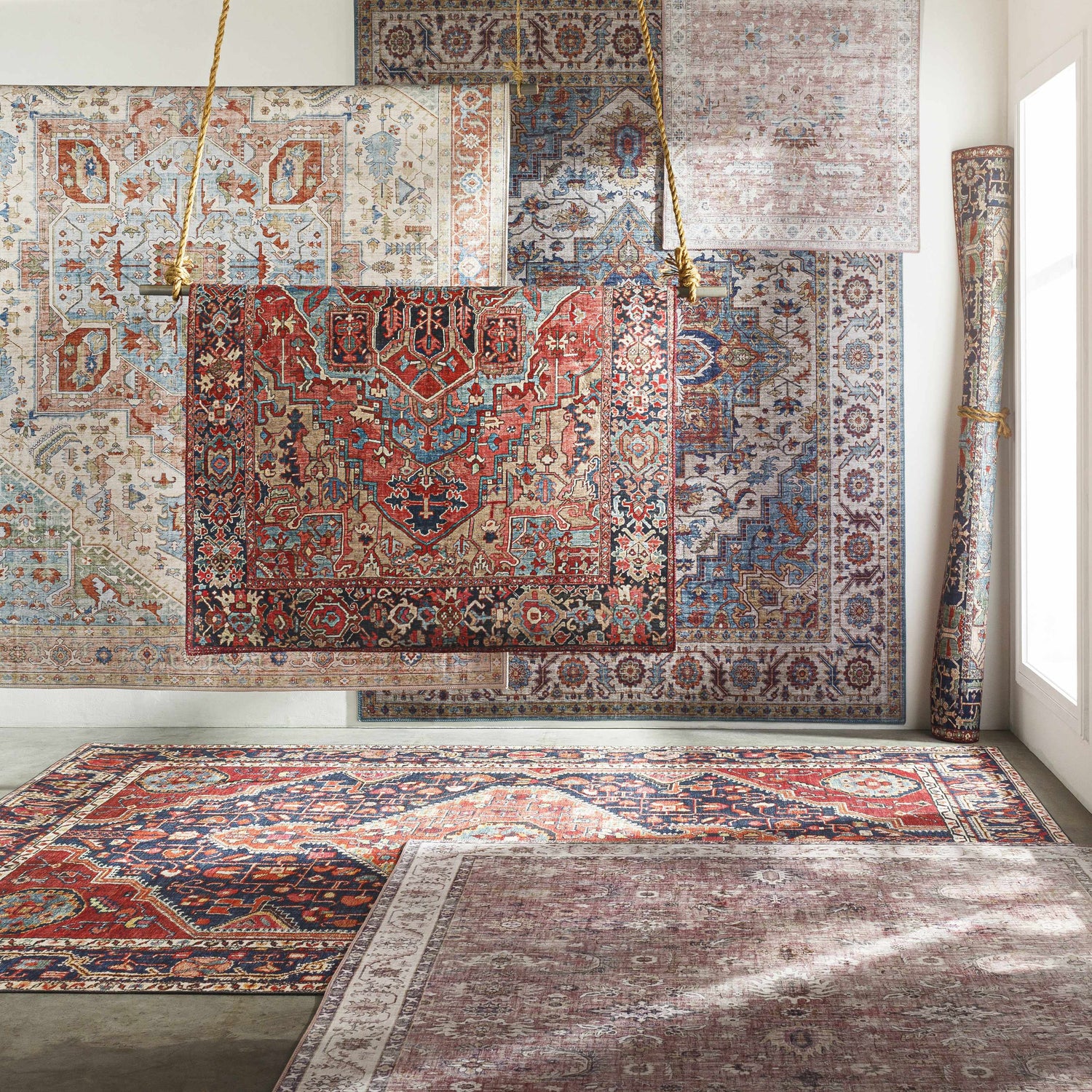 Showroom display of Selbyville Area Rugs in brick red, blue, and beige with traditional, oriental patterns. Styleshot