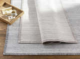 Close-up of the Nettleham Silver Viscose Rug showing its woven texture, charcoal and silver gray colors, and farmhouse style. Styleshot