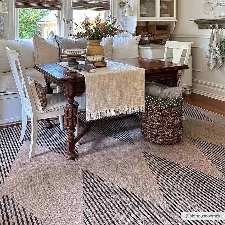 Farmhouse dining room with a camel Ijlal Washable Area Rug, dark wood table, white chairs, and neutral decor. Roomscene-Rectangle