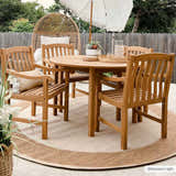 Outdoor patio scene with round wood table and Inigo Flatweave Faux Jute Rug in beige and brown. Wicker chair and umbrella in background. Roomscene-Round