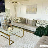 Living room with a gray sectional sofa and Ivory Alya 3D Medallion Fringe Area Rug, gold coffee table, and white walls. Roomscene-Rectangle