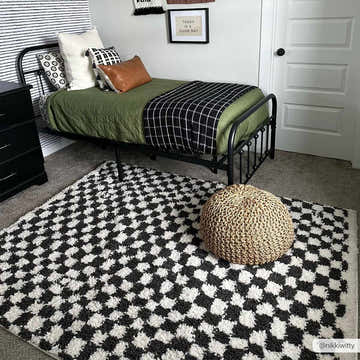 Kids room with a black metal bed and the Kieu Black & White Checkered Shag Rug. Pouf on the rug. Roomscene-Rectangle