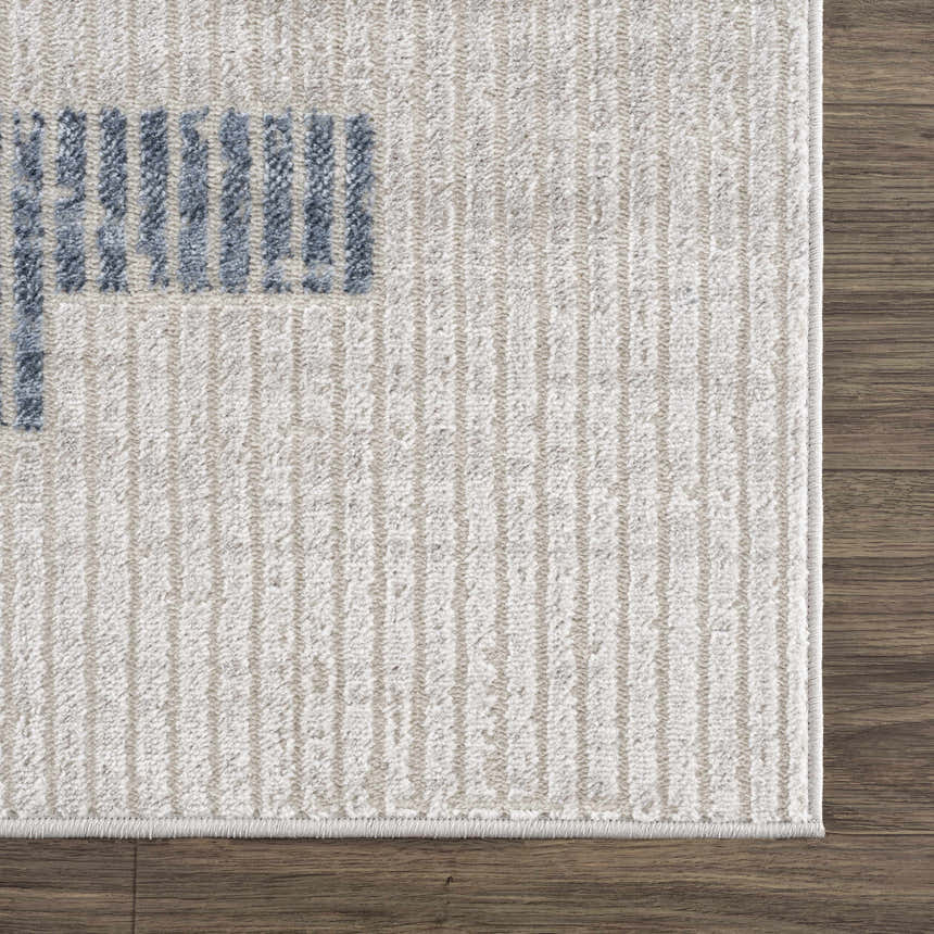 Close-up of Brisa Area Rug's gray and blue abstract pattern and textured weave on a dark wood floor. Swatch
