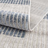 Close-up of the Brisa Area Rug, showing the blue and gray modern abstract design and soft, textured pile. Fold
