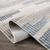 Close up of the Brisa Area Rug showing blue and gray geometric pattern and texture. Fold