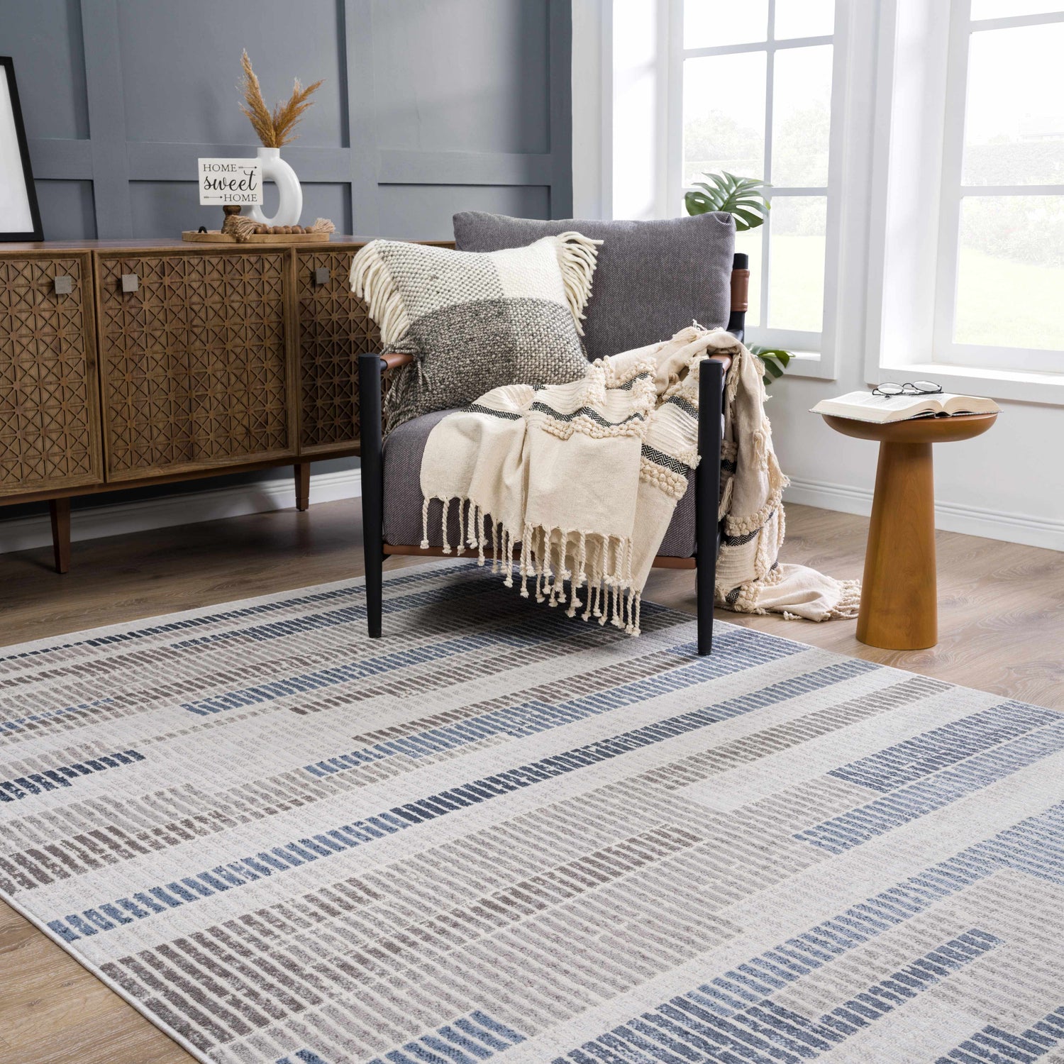 Living room scene with gray chair and Brisa Area Rug in blue and gray. Modern abstract design. Roomscene-Rectangle