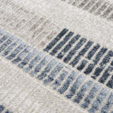 Close up of the Brisa Area Rug showing a textured, modern abstract design in blue, gray, and ivory. Texture