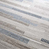 Close-up of the Brisa Area Rug, a modern rug with a blue and gray abstract stripe pattern and textured weave. Texture