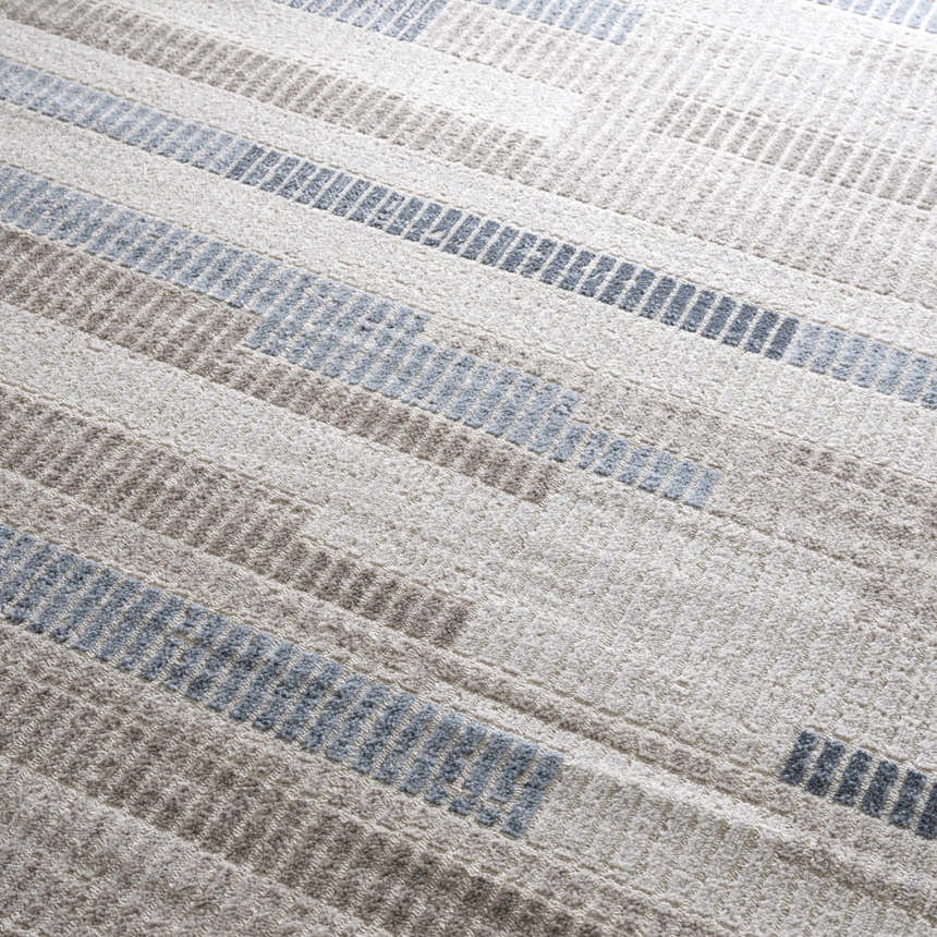 Close-up of the Brisa Area Rug, a modern rug with a blue and gray abstract stripe pattern and textured weave. Texture