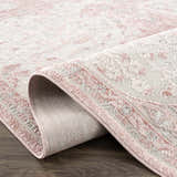 Close up of the Zora Pink Area Rug showing the traditional vintage pattern and soft pink hues. Fold