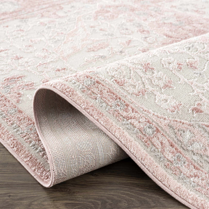 Close up of the Zora Pink Area Rug showing the traditional vintage pattern and soft pink hues. Fold