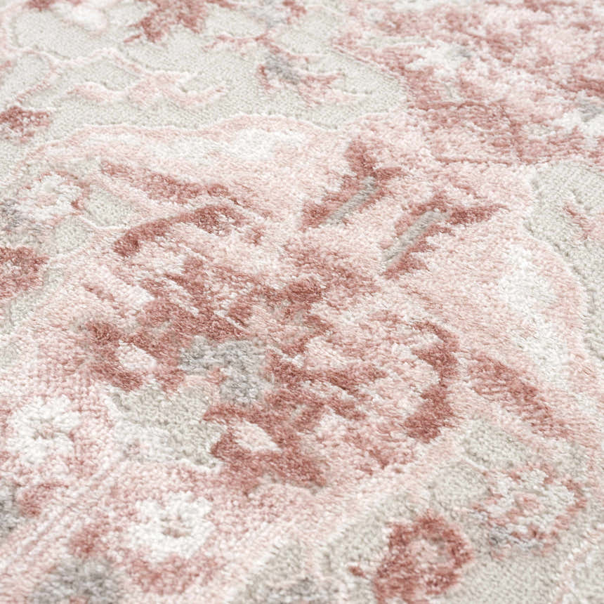 Close-up of the Zora Pink Area Rug showing its traditional floral pattern and soft pink and gray hues. Texture