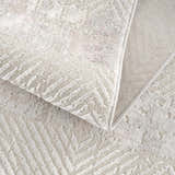 Close up of the Bucky Area Rug showing its gray and pink tones and geometric pattern. Fold