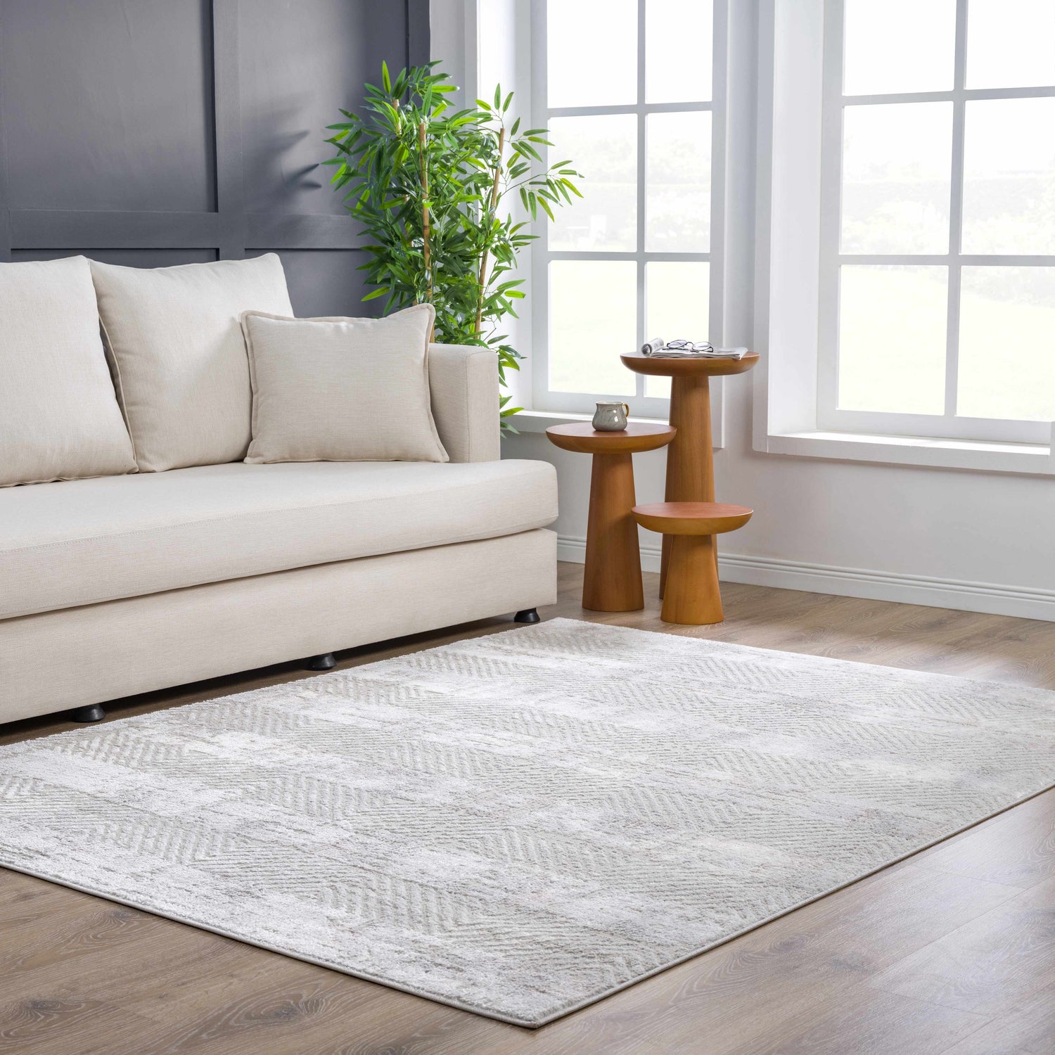 Living room scene with a gray and white Bucky Area Rug, cream sofa, and wood accent tables. Roomscene-Rectangle