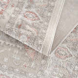 Close up of the Damla Area Rug in gray and pink, showing the traditional pattern and soft texture. Fold